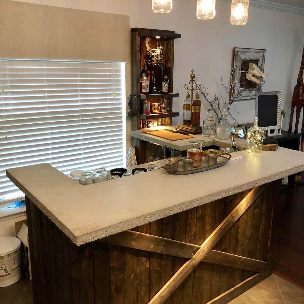 Rustic wet bar with concrete countertop, wooden base, illuminated shelves, and vintage decor.