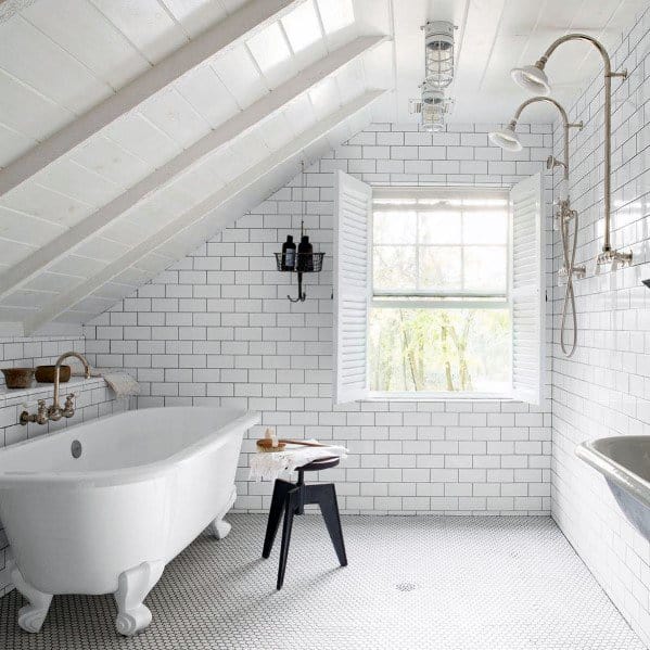 Attic bathroom with white subway tiles, freestanding tub, and shuttered window