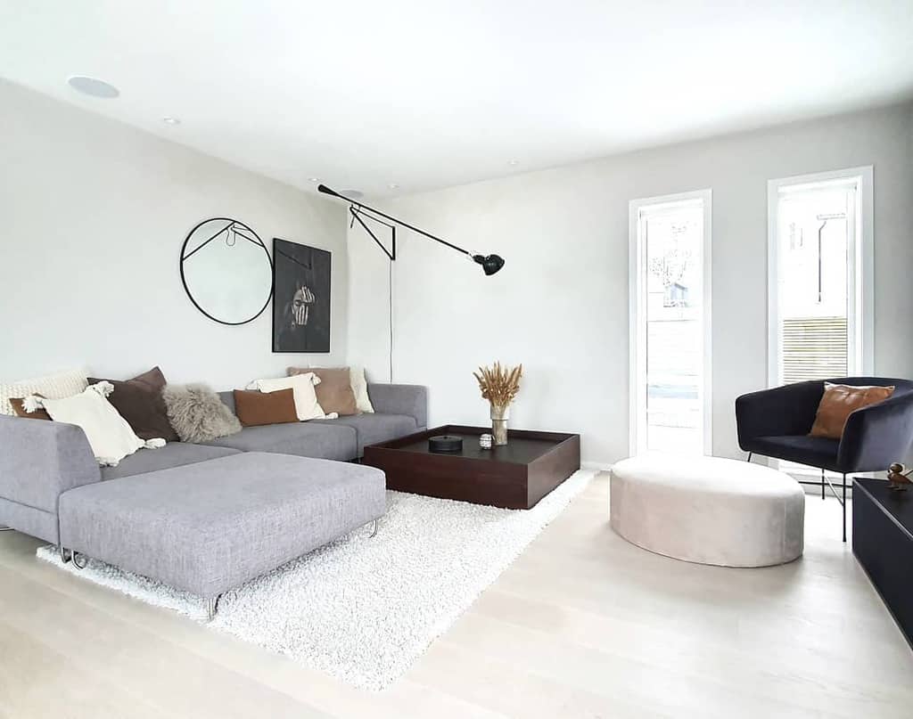 Scandinavian-inspired living room with a gray sectional, soft textures, minimalist wall art, and natural light for a serene ambiance