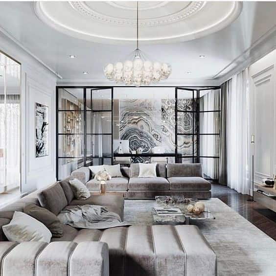 Luxurious living room with a large sectional sofa, ornate ceiling, and glass partition wall