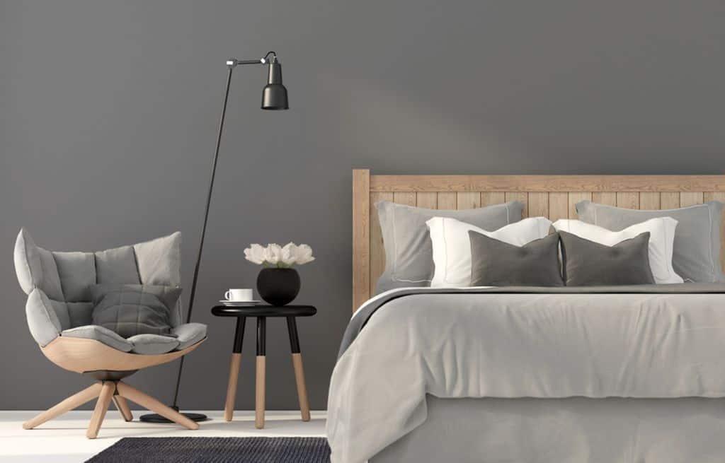 Sleek contemporary gray bedroom with wooden bed, accent chair, and floor lamp.