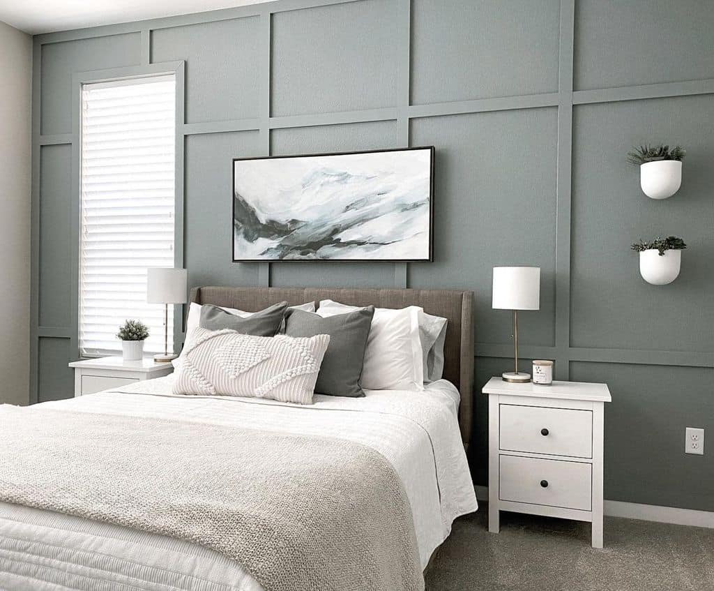 Green bedroom with textured accent wall, wall-mounted plants, and white bedside tables.