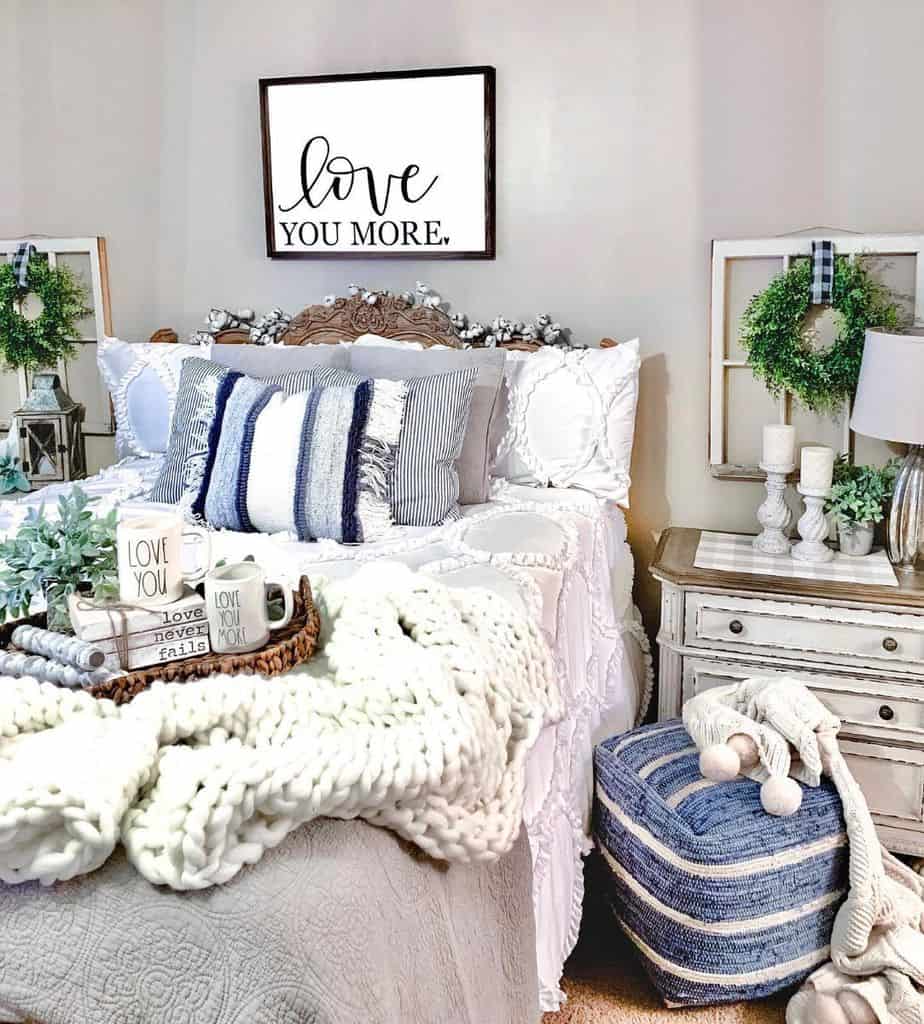 Homestyle bedroom with rustic furniture, cozy bedding, and framed "Love You More" wall art.