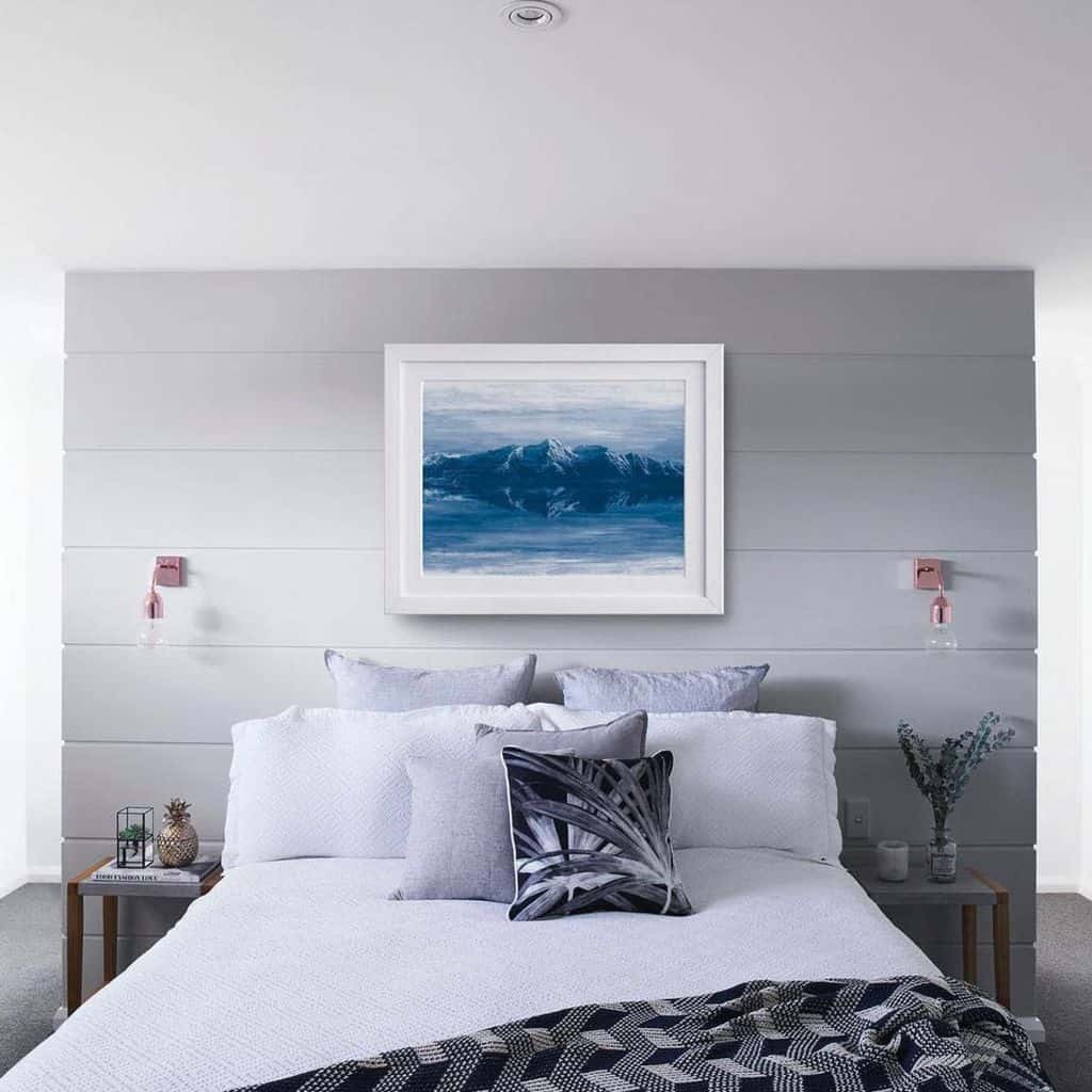 Gray bedroom with Arctic-themed wall art, white bedding, and modern bedside tables.