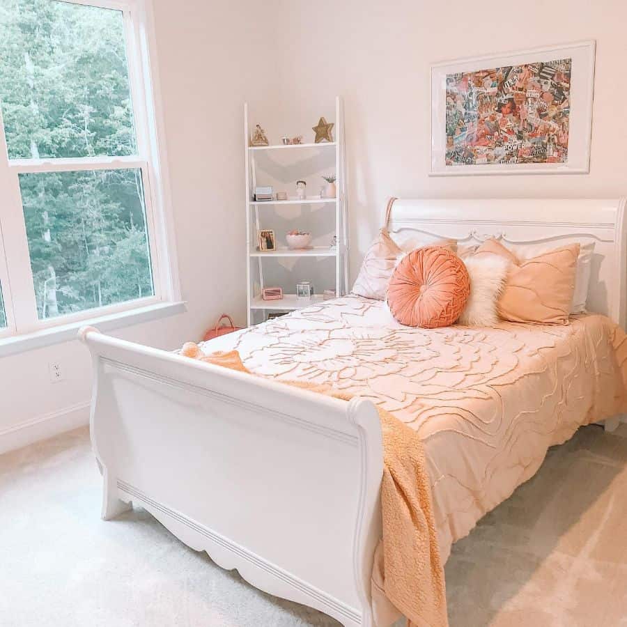 Bright bedroom with apricot bedding, white sleigh bed, and decorative ladder shelf.