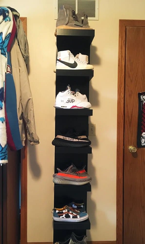 Vertical black wall-mounted shoe rack showcasing sneakers in a compact and stylish design for small spaces