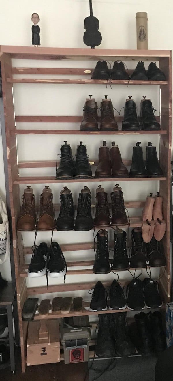 Large wooden shoe rack with multiple shelves, neatly organizing boots and shoes, with decorative items displayed on top