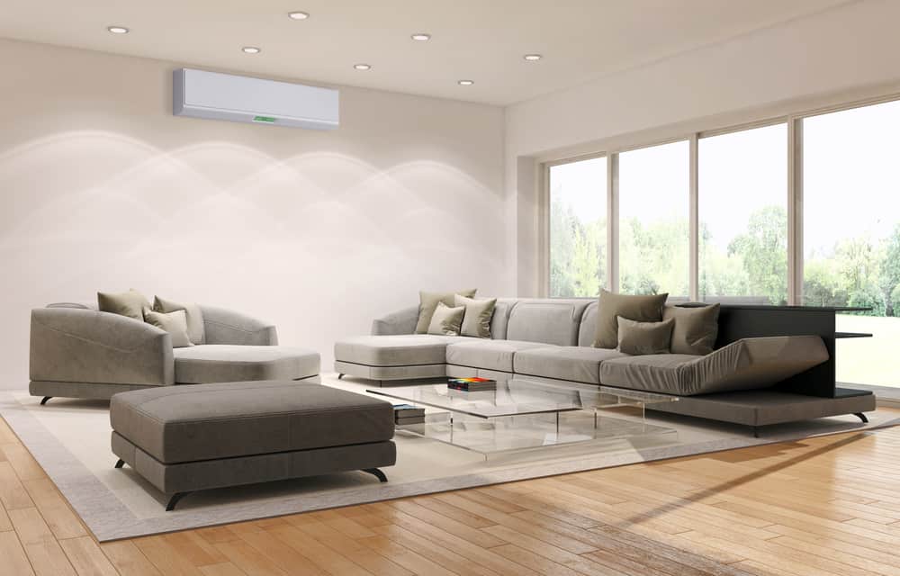 Spacious minimalist living room featuring a large sectional sofa, armchairs, and a glass coffee table, complemented by natural light