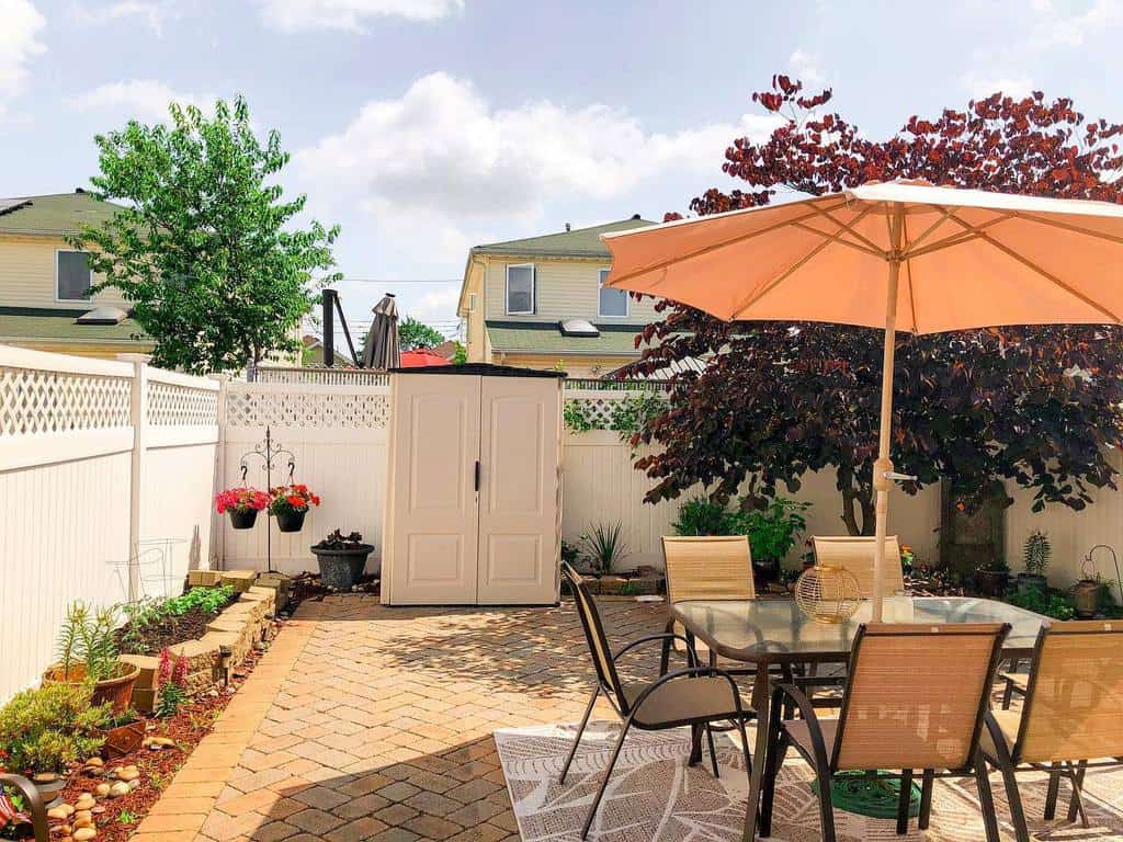 simple backyard paver patio with small shed 