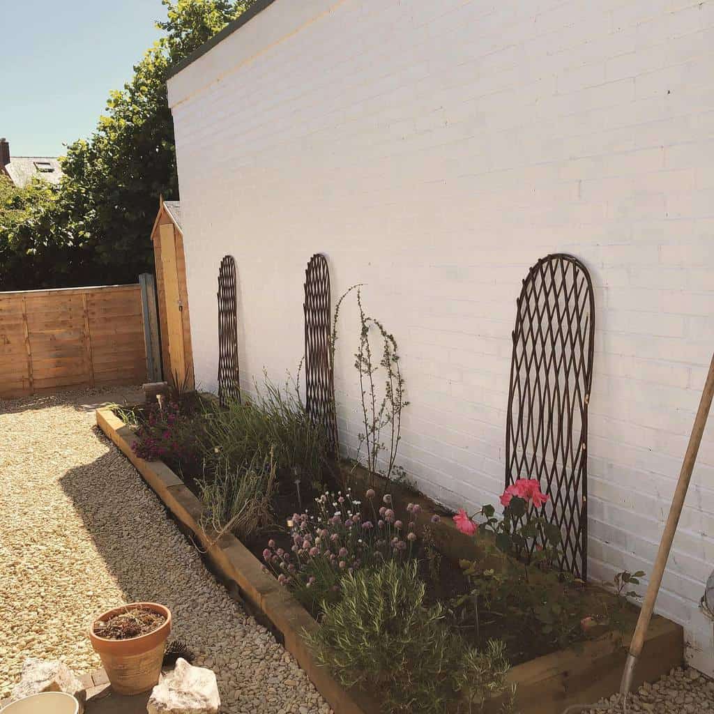 simple raised garden bed next to white brick wall