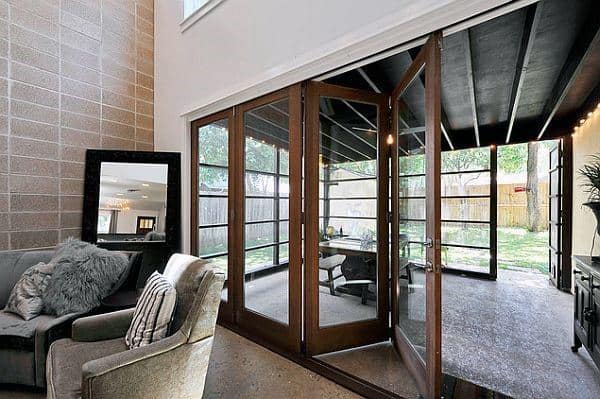 Modern sunroom with sliding glass doors, plush seating, and seamless patio views.