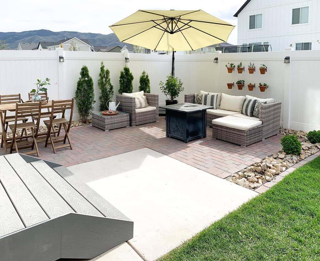 backyard brick patio with wicker furniture and umbrella