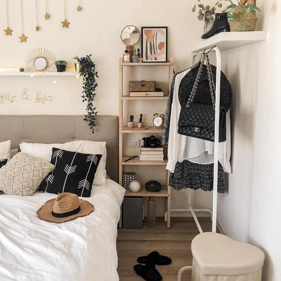 Boho bedroom with clothes rack, tall storage unit, and cozy decor accents.