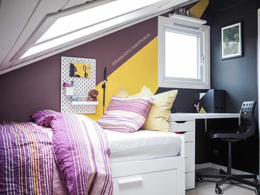 Modern attic bedroom with under-bed storage, small desk, and vibrant decor.