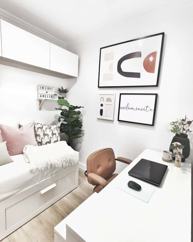 Small home office with white desk, wall art, built-in storage, and cozy decor.