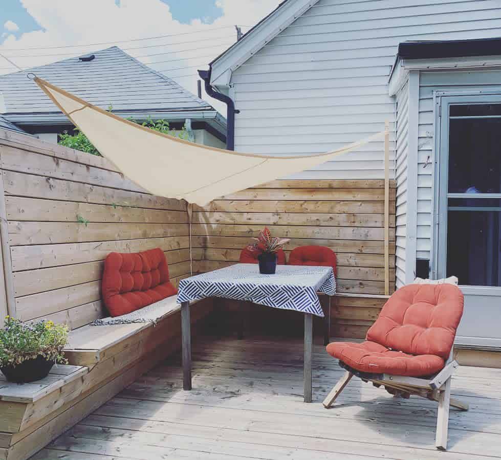 wood patio with wood privacy fence sun shade red cushions 