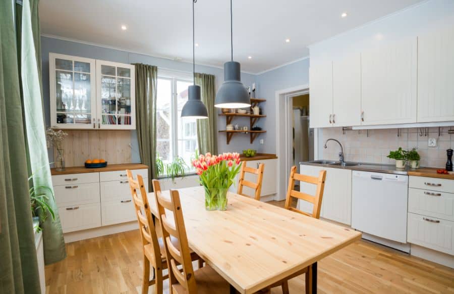 white cabinet kitchen with dining table 