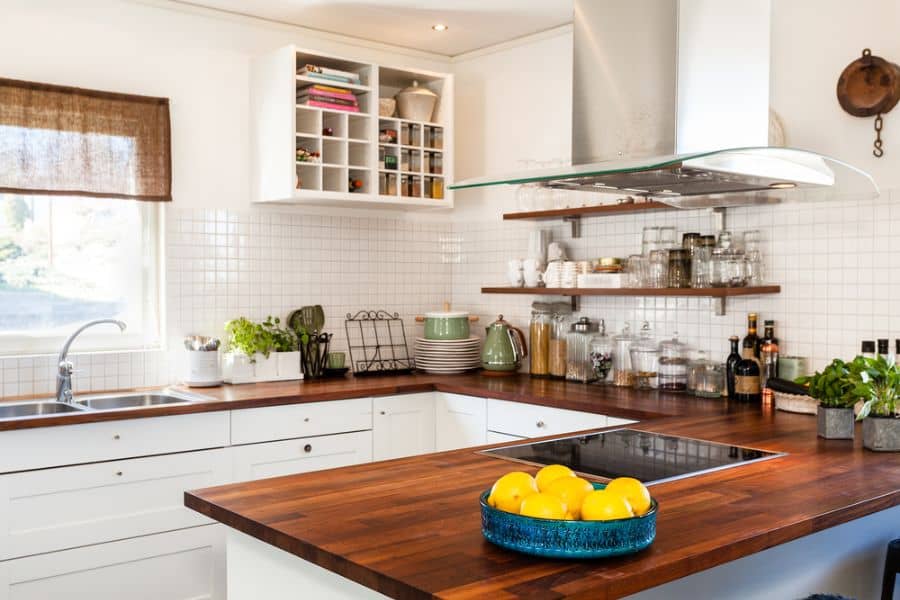 small kitchen with white cabinets and wood countertop 