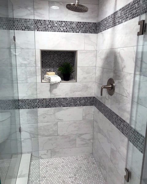 Modern marble shower with mosaic accent tiles, recessed shelf, and rainfall showerhead.