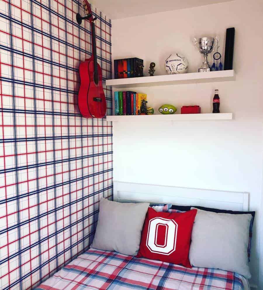 Plaid wallpapered bedroom with white shelves, red guitar, and patterned bedding.