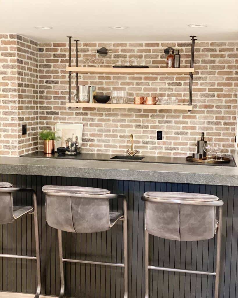 Rustic wet bar with exposed brick walls, open wooden shelving, and a sleek countertop for a cozy yet stylish vibe.