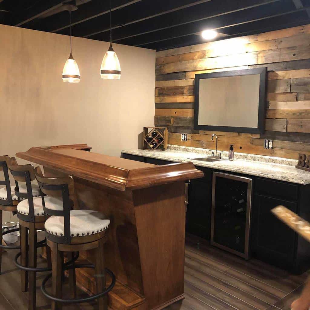 Rustic wet bar with a reclaimed wood backsplash, granite countertops, and a traditional wood bar counter, perfect for cozy gatherings.