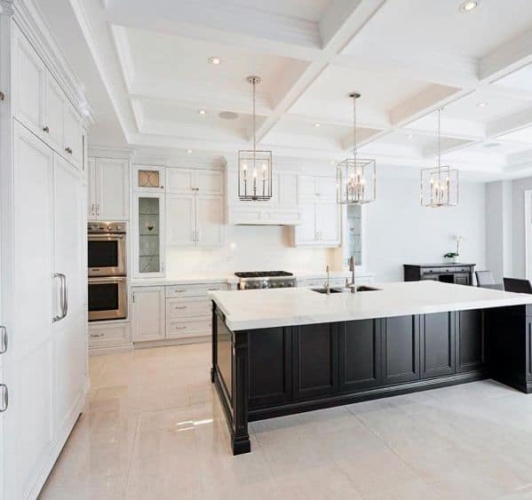 This kitchen features a stunning black and white design with elegant square metal chandeliers above a spacious island, offering a sophisticated atmosphere