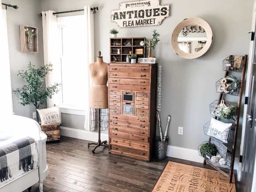 Vintage bedroom with wooden tallboy dresser, mannequin, and ladder rack with baskets.