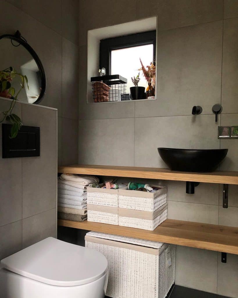 Modern bathroom with wooden shelves, black vessel sink, and woven storage baskets.