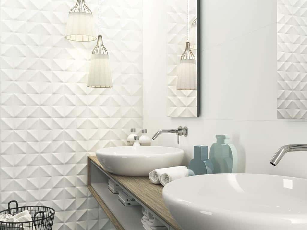 Modern bathroom with vessel sinks, textured white wall tiles, and low-hanging pendant lights.