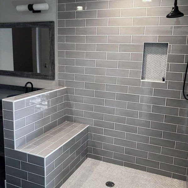 Modern bathroom with grey subway tiles and a built-in shower bench