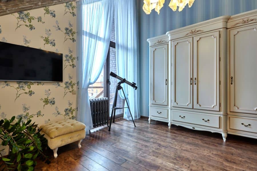 apartment spare room with white cabinets and telescope