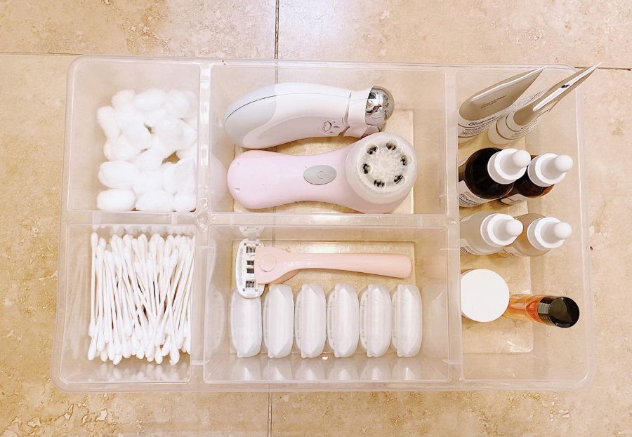 Bathroom storage organizer with cotton swabs, facial devices, and skincare products.