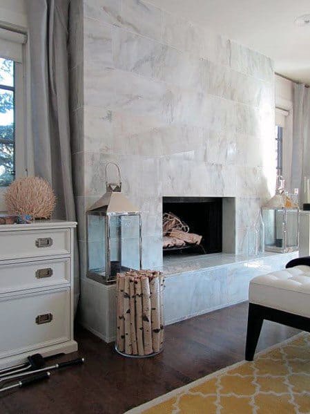 Traditional living room with a white tiled fireplace and built-in wood storage.