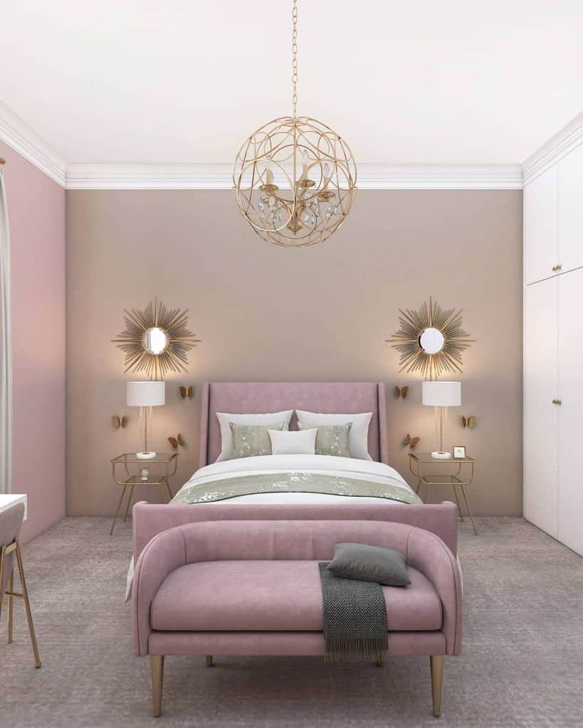 Pastel bedroom with pink bed and couch, gold accents, mirrored nightstands, and chandelier.