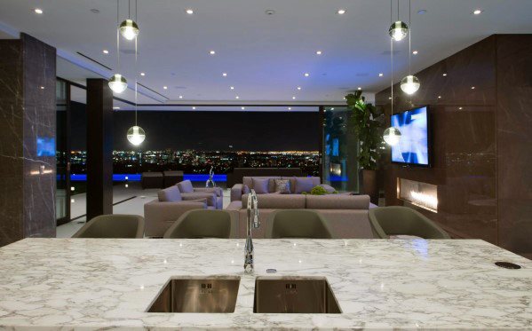 A sleek modern kitchen with crystal glass ball lights hanging above the island, providing a contemporary feel while offering stunning views of the city at night