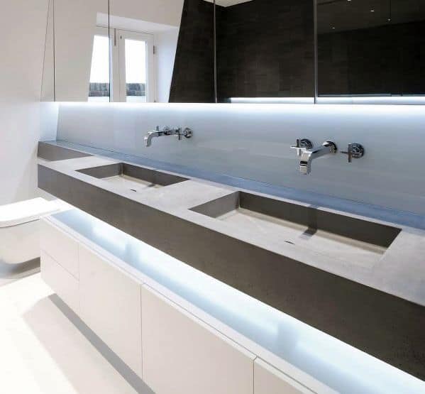 Modern bathroom with concrete double sink, LED backlighting, and minimalist design.