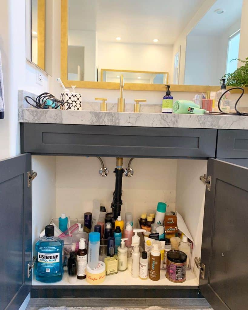 Open shelving with wicker baskets, towels, potted plant, and wicker bin in a bathroom corner.