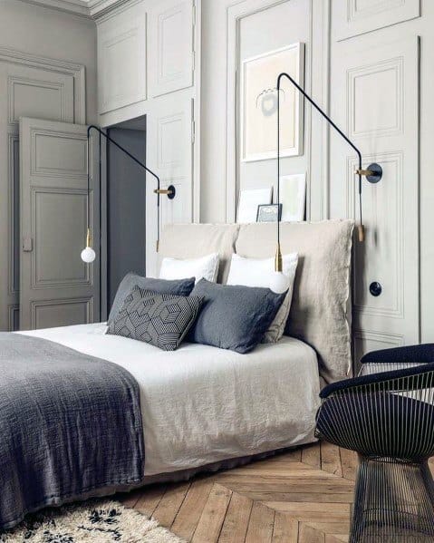 Elegant European-inspired bedroom with wall-mounted lighting and neutral color palette.