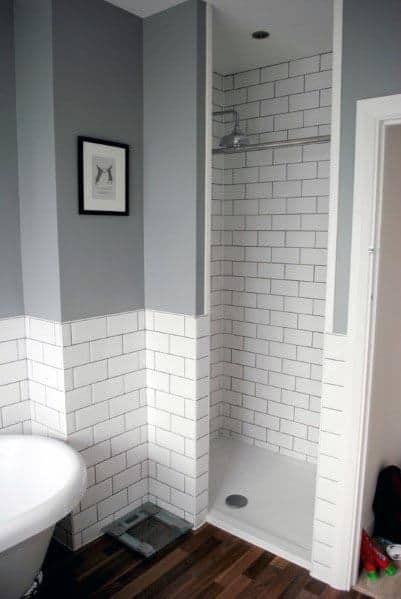 Rustic grey bathroom with wooden vanity, vessel sinks, and glass shower.