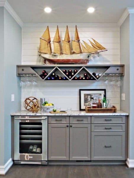 Nautical-themed mini bar with gray cabinetry, wine storage, a beverage fridge, and ship decor.