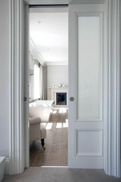 Elegant white pocket door with detailed paneling and a smooth, minimalist finish, perfectly complementing the clean and refined living room interior