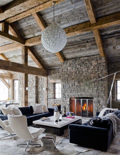 high ceiling living room with stone fireplace and blue sofas 