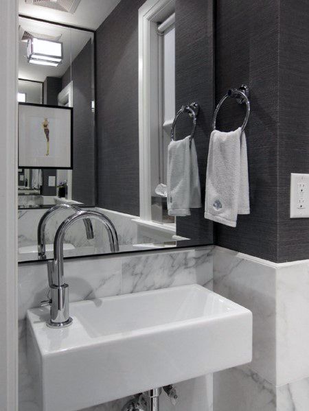 Modern bathroom with gray textured walls, marble backsplash, and rectangular white sink.