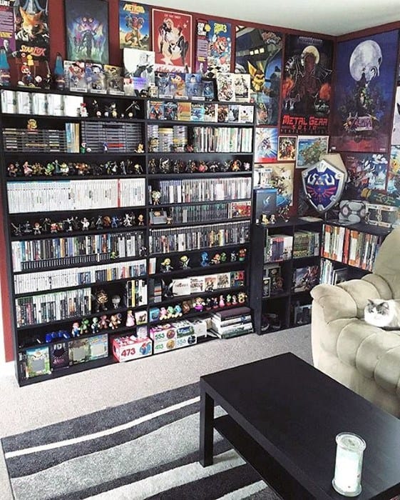 A cozy gaming room with shelves filled with video games, collectibles, and posters on the walls, plus a relaxing chair