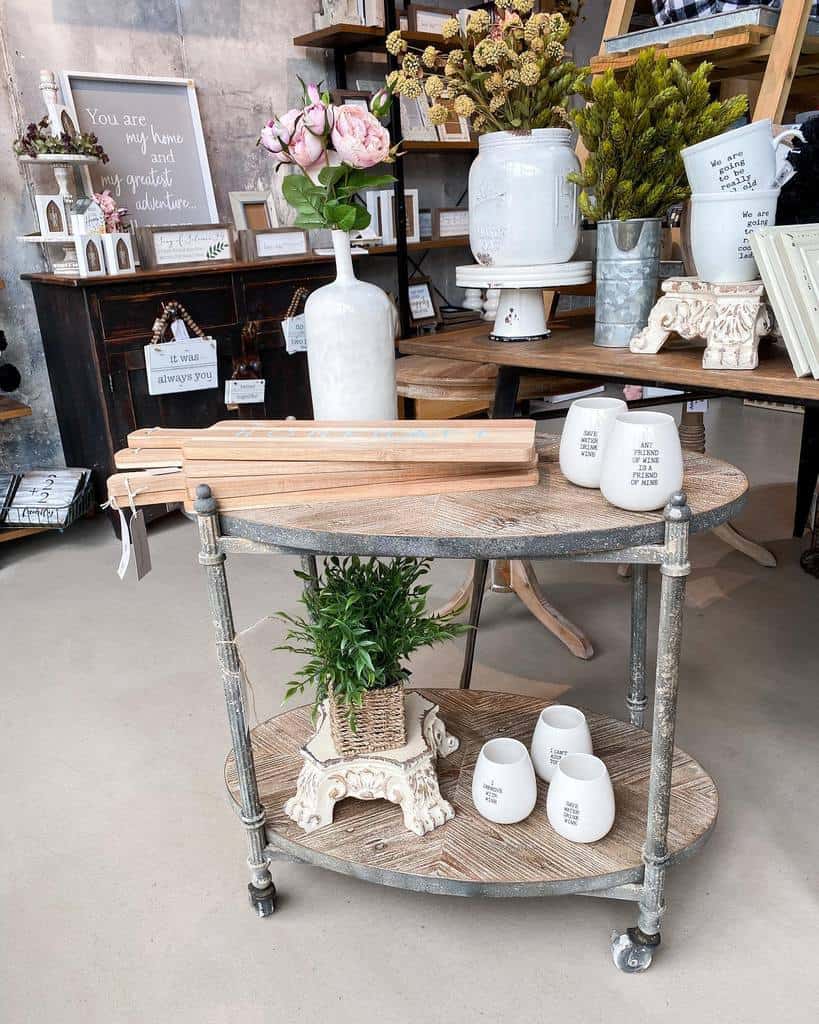 Steel and wood bar cart with rustic decor, including vases, plants, and ceramic mugs.