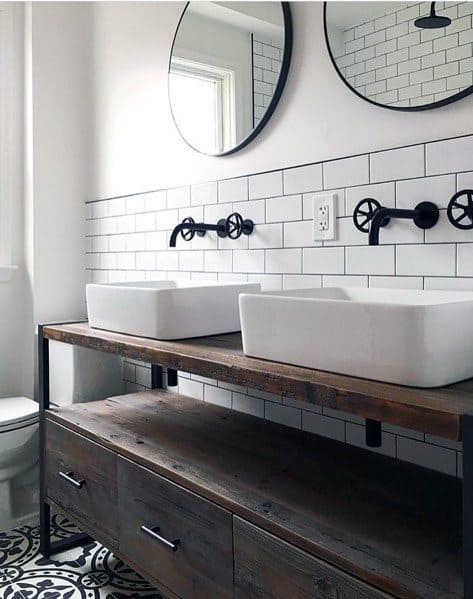 Bathroom with white beveled subway tile backsplash, industrial fixtures, and wooden vanity.