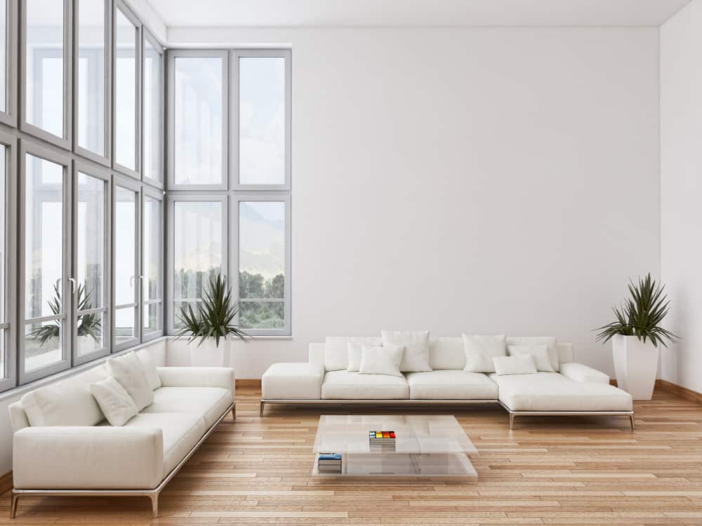 Bright minimalist living room with white seating, floor-to-ceiling windows, and sleek decor for an airy and spacious feel