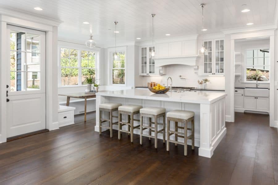 large white kitchen with island and dining table 