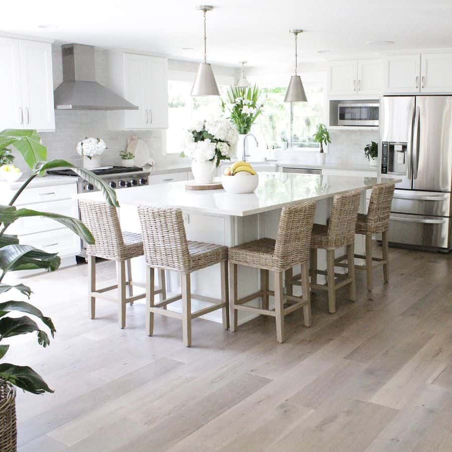 white cabinet kitchen with weaved seats around island 